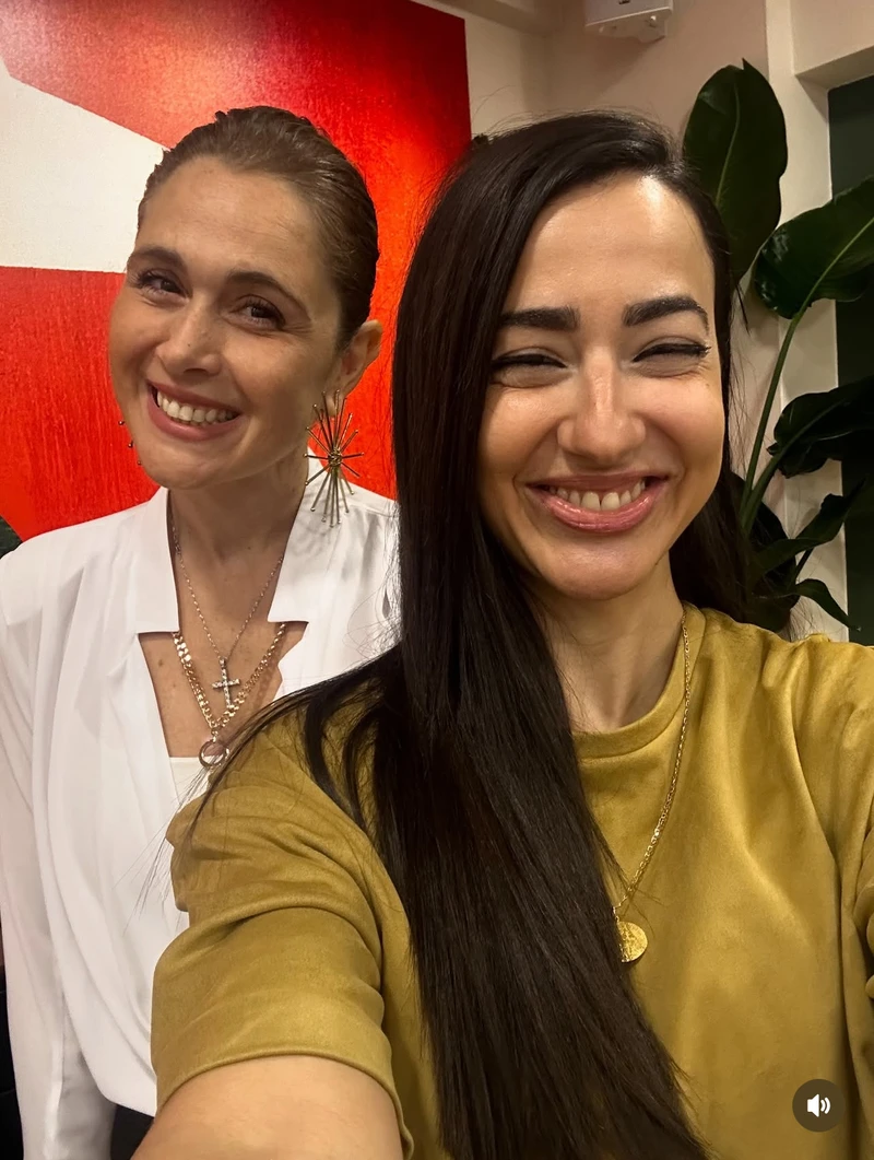 Two women smiling together — a behind-the-scenes moment